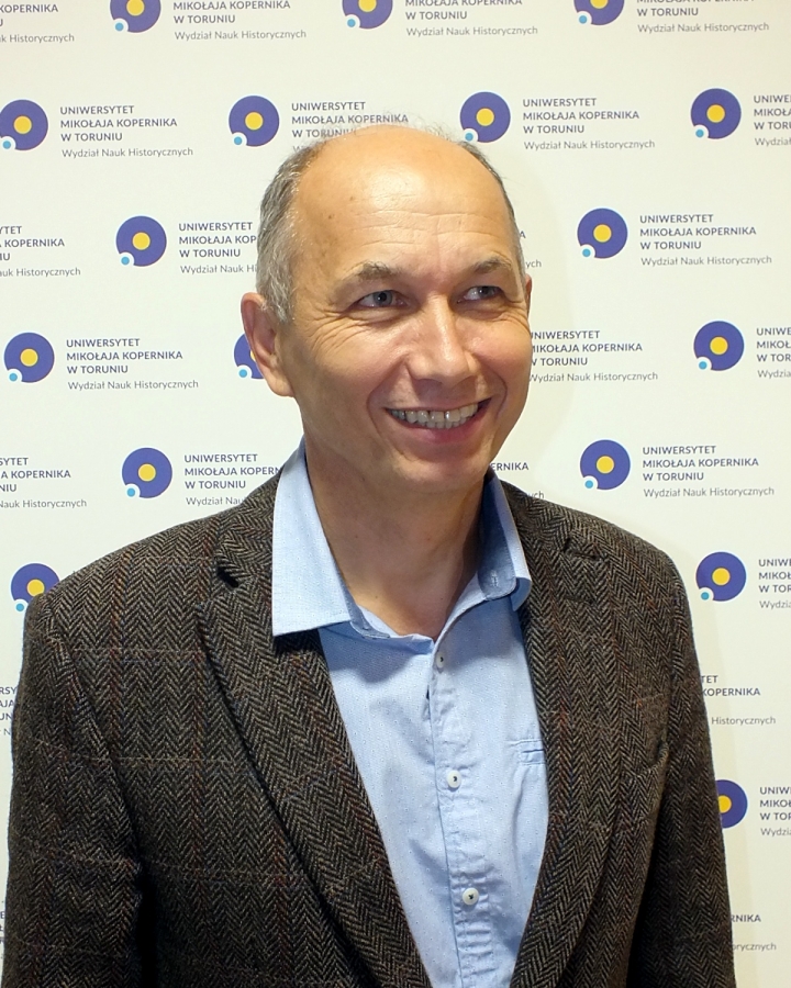 Profesor Roman Czaja fot.Krystian Chyrkowski Profesor Roman Czaja z Instytutu Historii i Archiwistyki UMK na tle ścianki reklamowej Wydziału Nauk Historycznych UMK