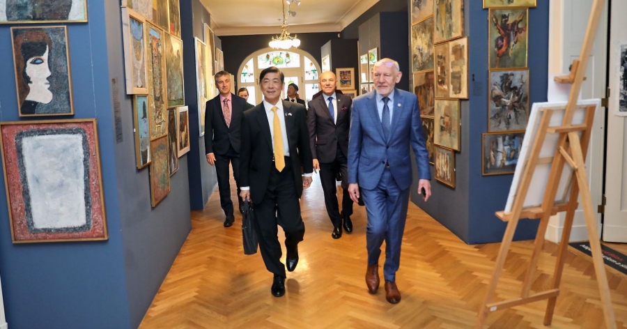 obrazek: fot.fot. Andrzej Romański Ambasador Japonii oraz Rektor UMK idący przez korytarz. Na drugim planie prorektor Wojciech Wysota i pozostali uczestnicy spotkania.