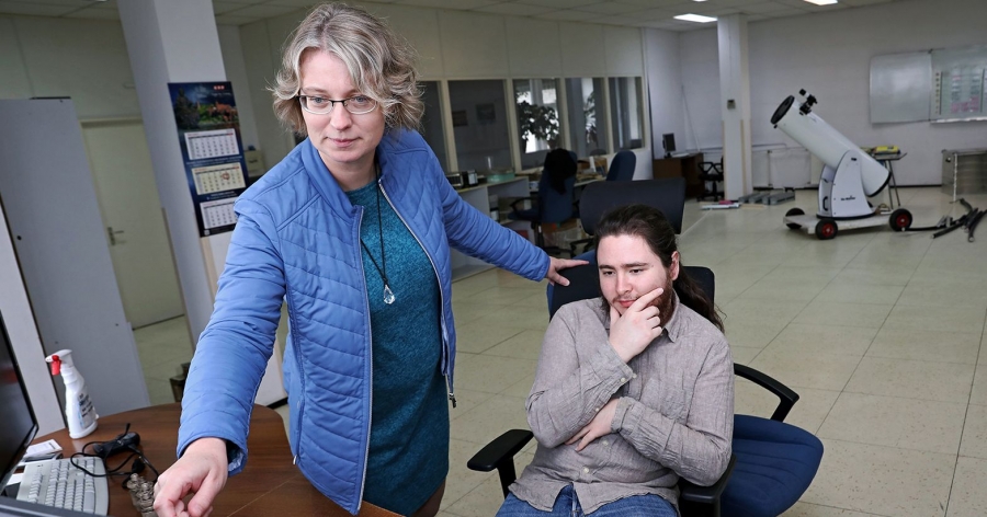 Prof. Anna Bartkiewicz i mgr Michał Durjasz z Instytutu Astronomii na Wydziale Fizyki, Astronomii i Informatyki Stosowanej fot.fot. Andrzej Romański Przy biurku stoi kobieta, młody mężczyzna siedzi na krześle