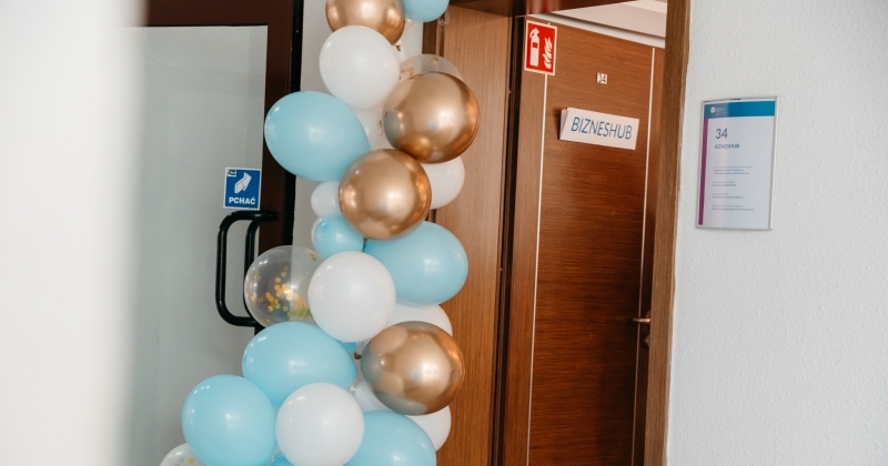 Zdjęcie otwartych drzwi, a wokół balony