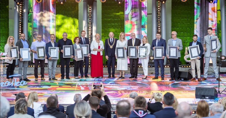 Badaczki i badacze z UMK rozbili także bank wyróżnień w kategorii "Nauka, badania naukowe i postęp techniczny" fot.fot. Szymon Zdziebło/tarantoga.pl dla UMWKP Grupa osób z dyplomami w ramkach i swóch nagrodzonych ze statuetkami stoi na scenie wraz z marszałkiem i przewodniczącą sejmiku województwa