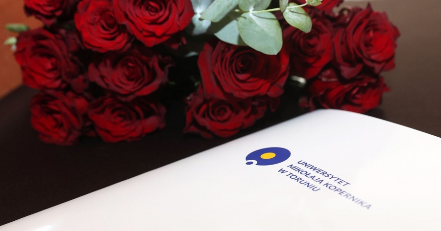 fot.fot. Andrzej Romański Teczka z logo UMK i bukiet róż leżą na stole