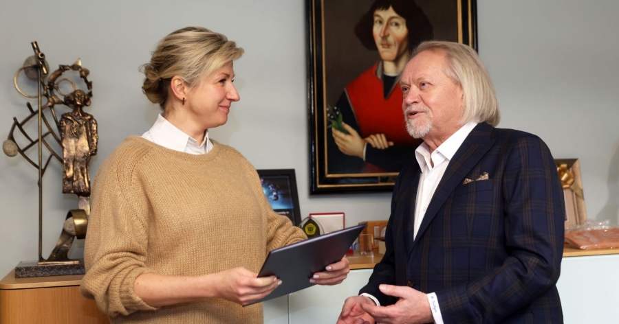W imieniu zespołu Interdyscyplinarnego Centrum Nowoczesnych Technologii Nagrodę Specjalną Rektora UMK odebrała dr Aleksandra Wypych fot.fot. Andrzej Romański Dr Aleksandra Wypych odbiera nagrodę od rektora UMK. W rękach trzyma teczkę, w tle widać portret Mikołaja Kopernika.