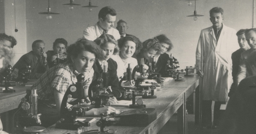 In the academic year 1945/1946, there were 1605 students enrolled at the Nicolaus Copernicus University in Toruń. photo:NCU Archive an old, black and white photo of the first students of the NCU in a laboratory