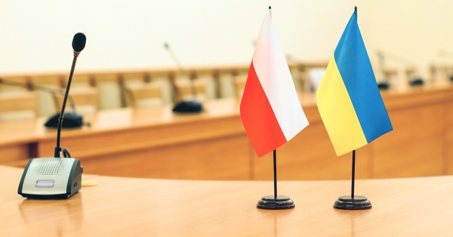 VII Spotkania Polsko-Ukraińskie fot.źródło: Canva Flagi Polski i Ukrainy stojące na biurku obok mikrofonu