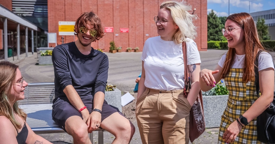 Every person studying at UMK has received a link to the survey in their student email account photo:Andrzej Romański Four smiling students in front of a red brick building