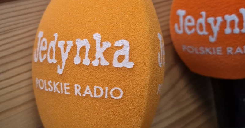 Mikrofony z napisem Jedynka Polskie Radio leżące na stole