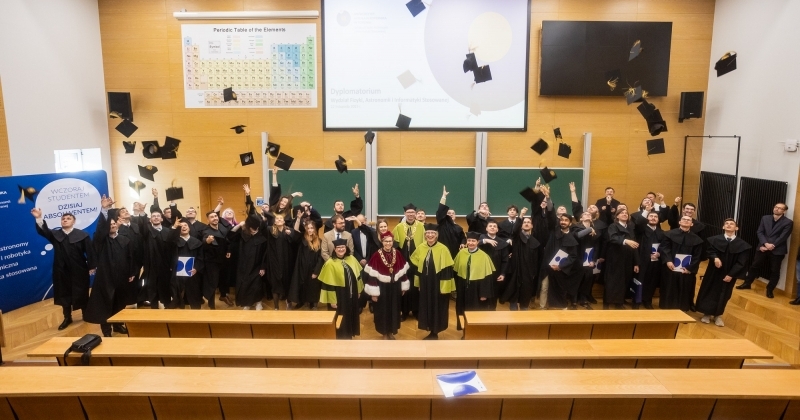 Studenci podrzucający birety w Audytorium Aleksandra Jabłońskiego