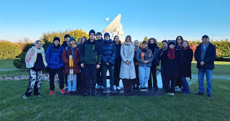 Uczniowie i prowadzący warsztaty stojący w holu instytutu astronomii w Piwnicach