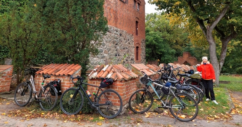 na zdjęciu grupa rowerów, w tle mury zamku