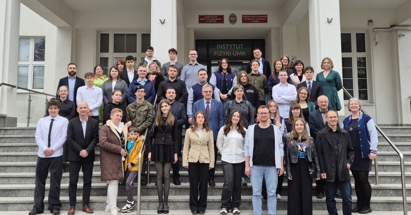 Ludzie stojący na schodach przed budynkiem Instytutu Fizyki