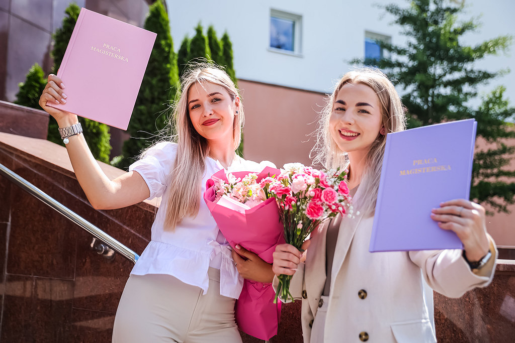 Female NCU graduates presenting their degree certificates [photo: Andrzej Romański]