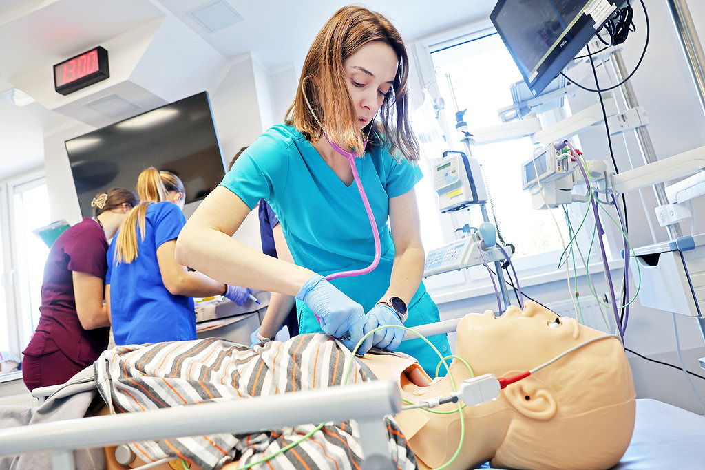A woman in a lab coat practising on a medical mannequin at the Center for Medical Simulations of the NCU Collegium Medicum [photo: Andrzej Romański]