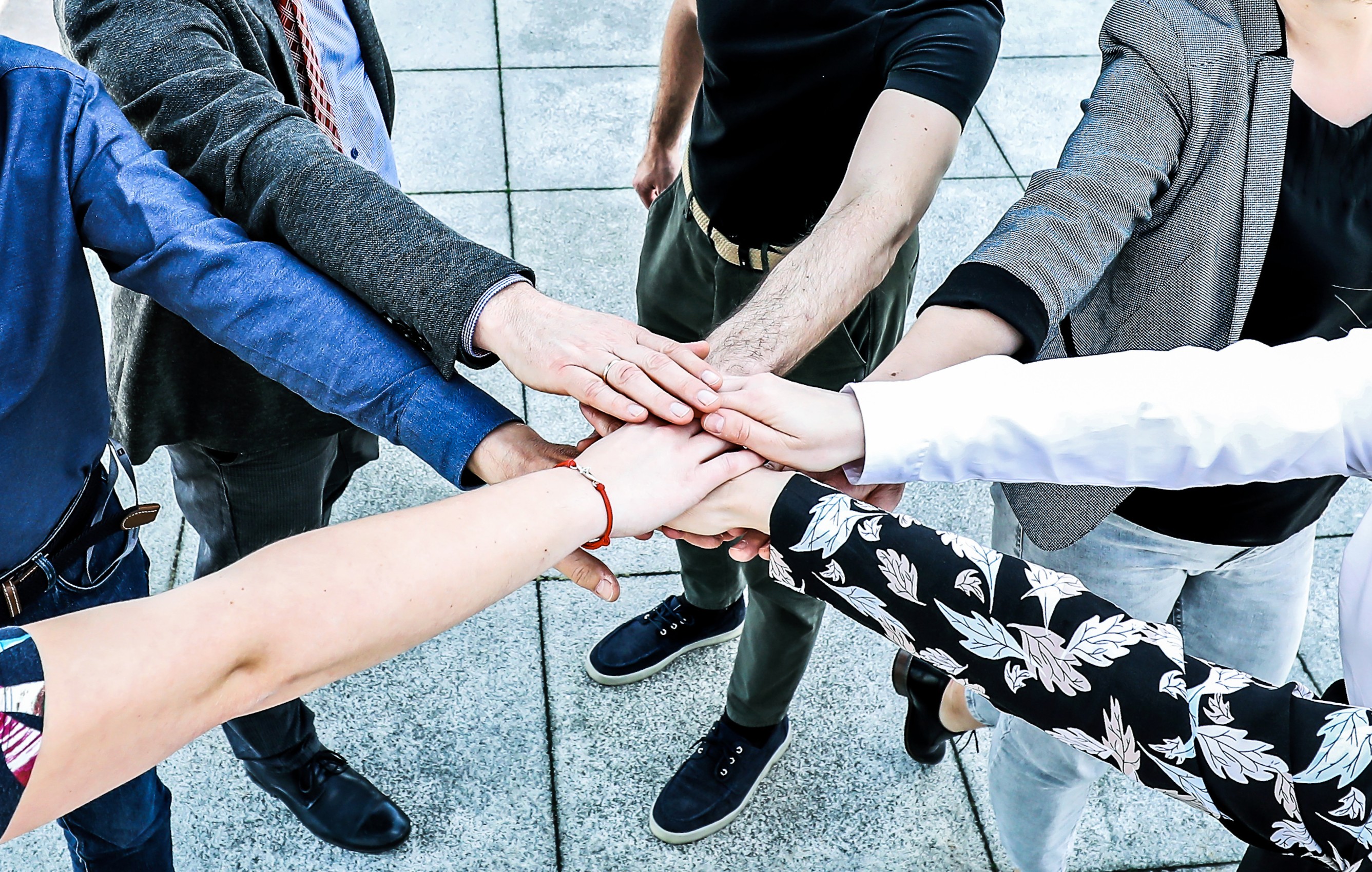 Grupa student&oacute;w trzymająca się za ręce.