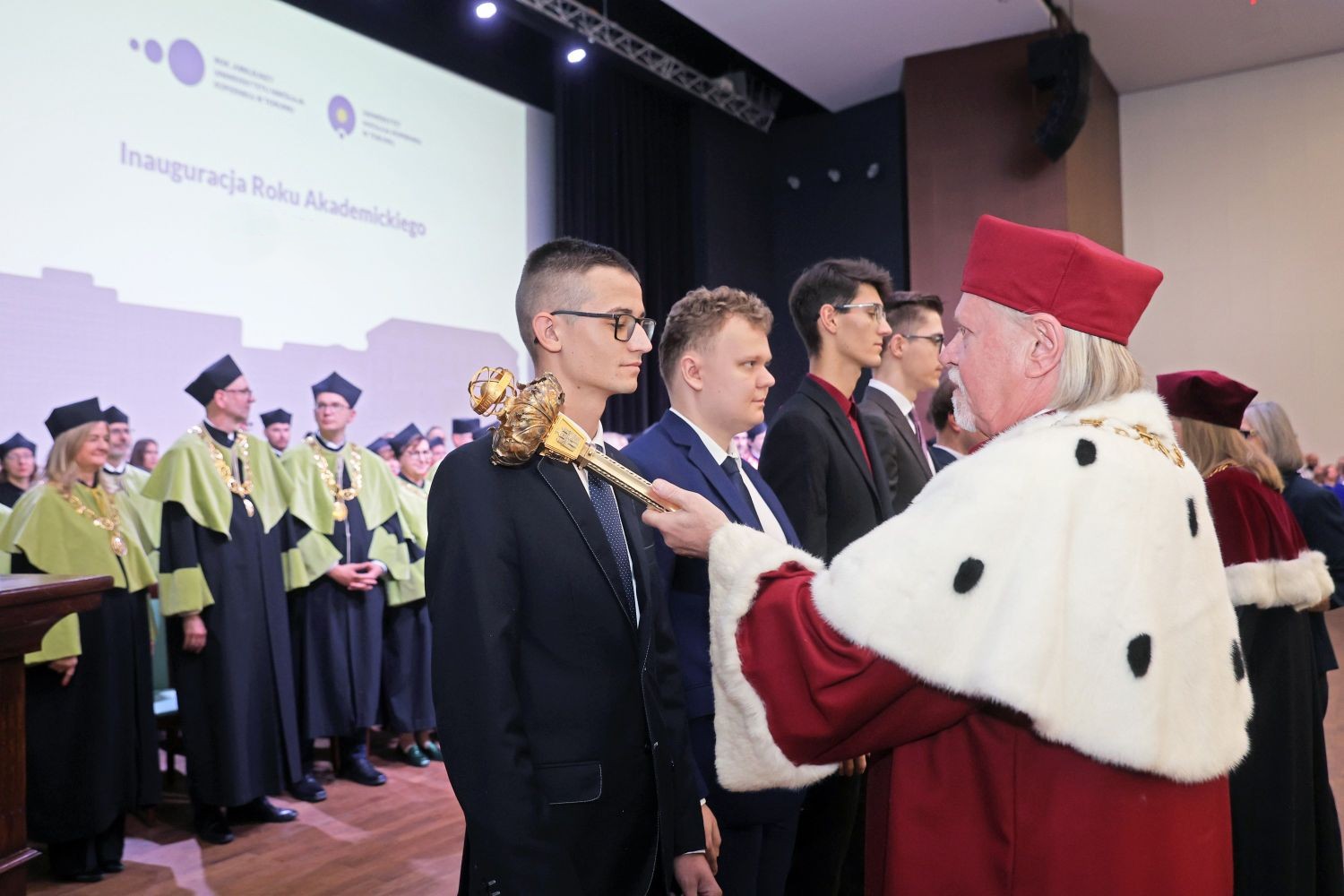 Pasowanie na studenta w trakcie inauguracji, rektor złotą buławą pasuje kolejnych student&oacute;w