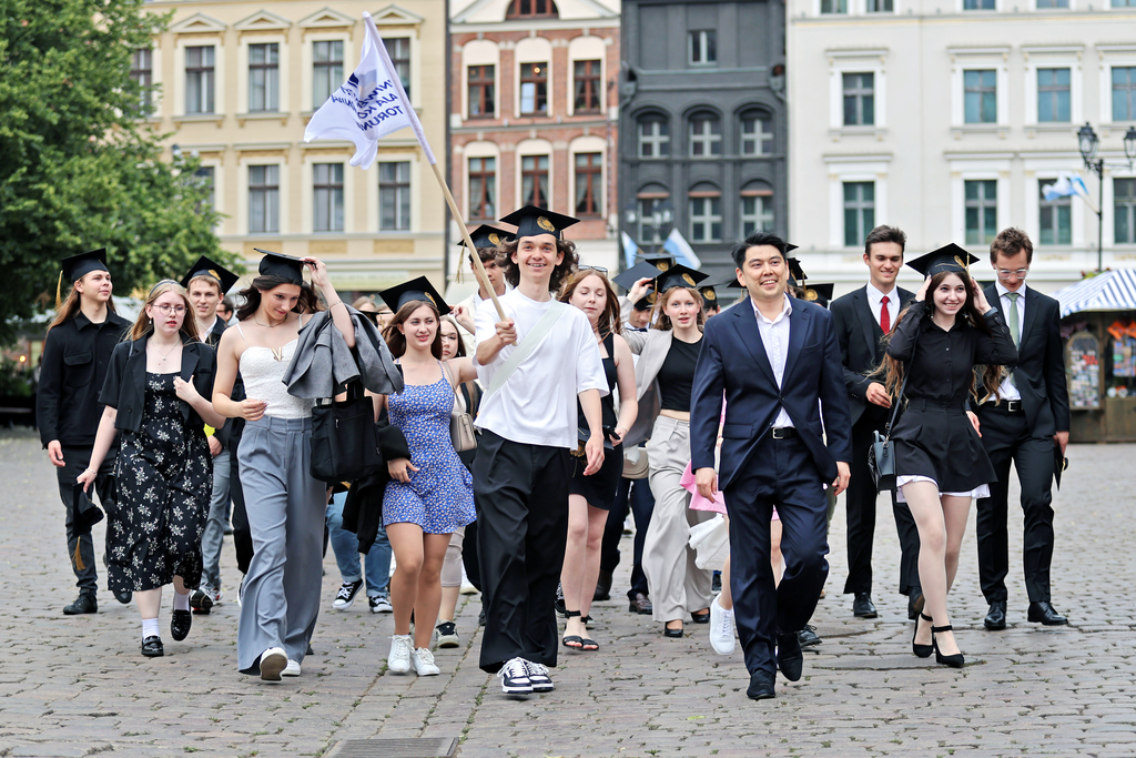 a procession of NCU students wearing academic caps through the Old Town