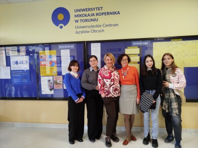 In the foreground, students and lecturers of English are standing in a row, smiling. In the background, above the heads of the students, there is an inscription: University Centre for Foreign Languages. Click to zoom the picture.