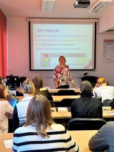 in the photo a classroom, the lecturer presents a slide, students sit at desks and attend a class. Click to zoom the picture.