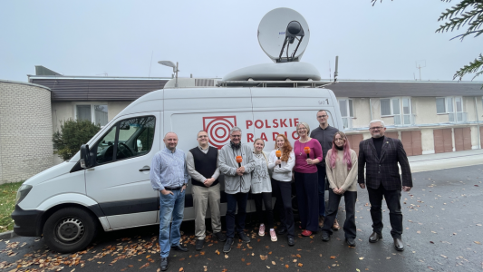 Osoby stojące na tle wozu transmisyjnego PR Jedynka. Kliknij, aby powiększyć zdjęcie.