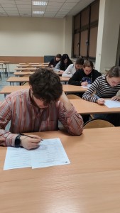 kilka osób w sali wykładowej rozwiązuje test. Kliknij, aby powiększyć zdjęcie.