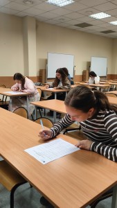 kilka osób w sali wykładowej rozwiązuje test. Kliknij, aby powiększyć zdjęcie.