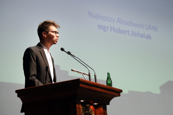 Rektor UMK ściskający dłoń Najlepszego Absolwenta UMK