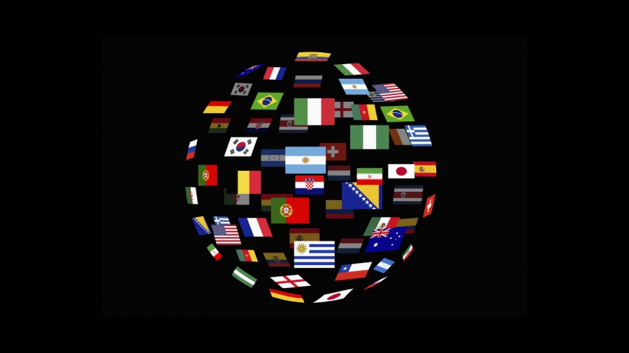 Na czarnym tle kula ziemska stworzona z rozporoszonych i prostokątnych flag państw. 