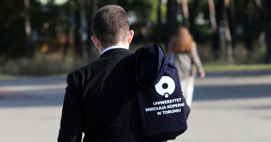 Człowiek z torbą z logo UMK