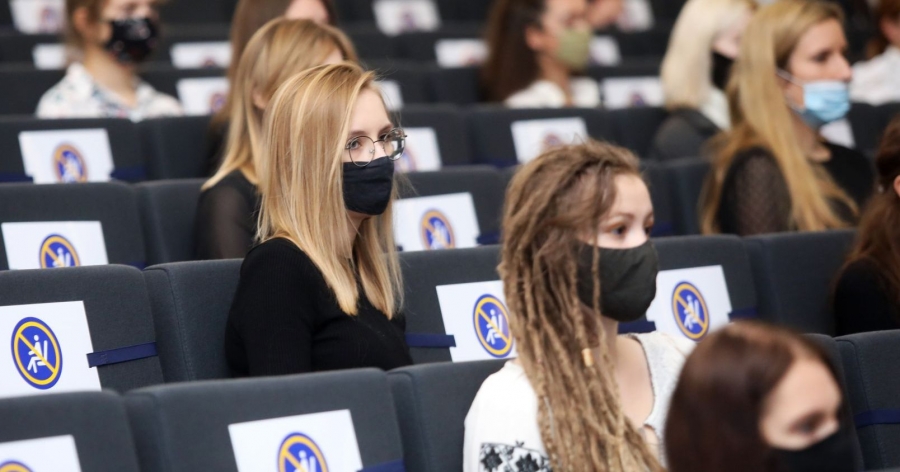 Studentki w maseczkach ochronnych siedzące w auli UMK