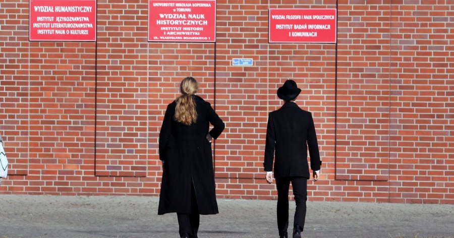 Two people standing next to Collegium Humanisticum