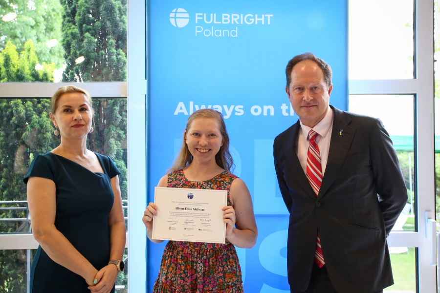There are three people in the photo, in the middle - Alison McIsaac, poses with the diploma, on her right the US Ambassador Mark Brzeziński, on the left Justyna Janiszewska Janiszewska, Executive Director of the Polish-U.S. Fulbright Commission