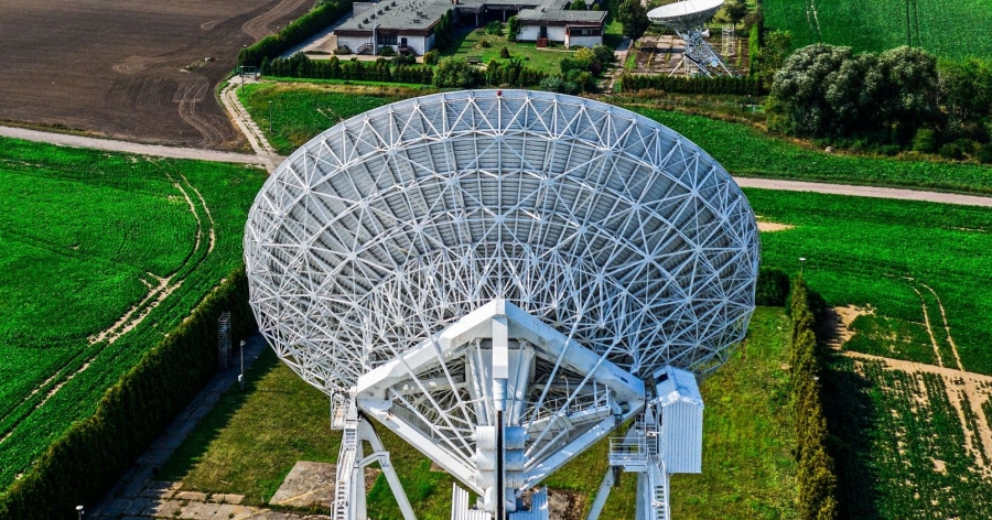 Na pierwszy planie radioteleskop, na drugim: zabudowania Obserwatorium Astronomicznego UMK w Piwnicach