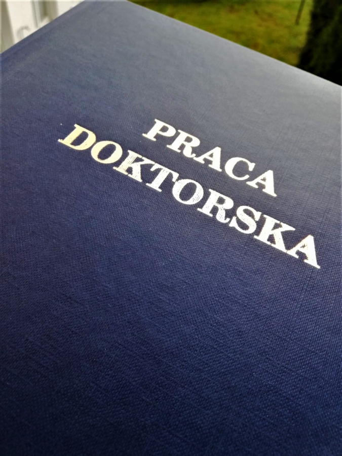 1 egzemplarz pracy doktorskiej w granatowej okładce.