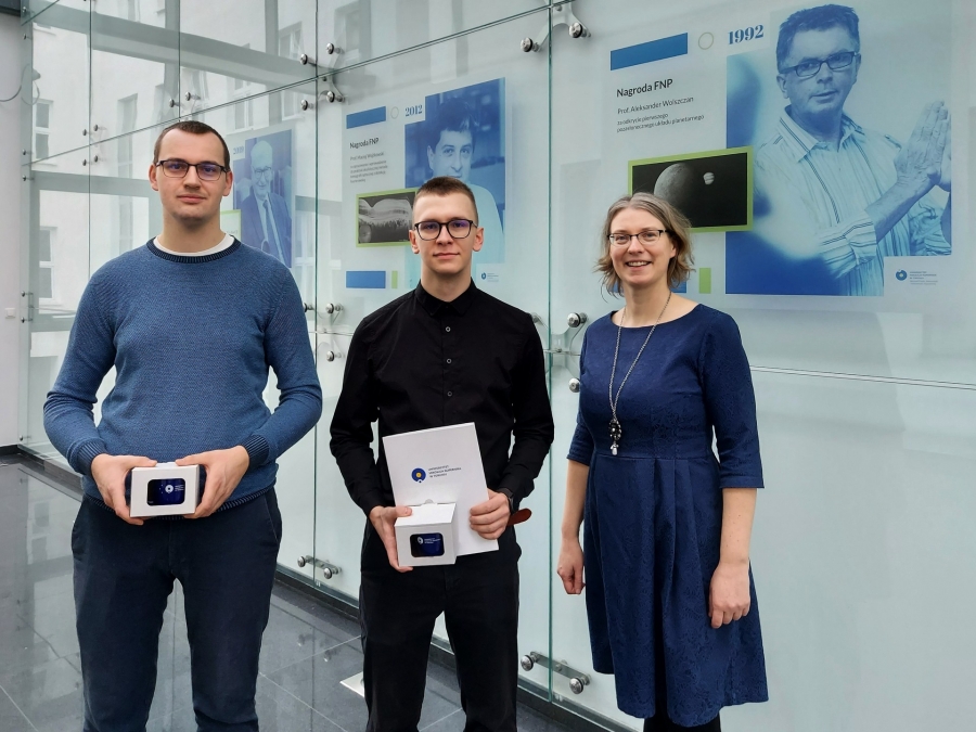 Stojące trzy osoby w Atrium SOK Instytutu Fizyki: mgr inż. Rafał Szczepański, inż. Hubert Stefaniak, dr hab. Anna Bartkiewicz, prof. UMK.