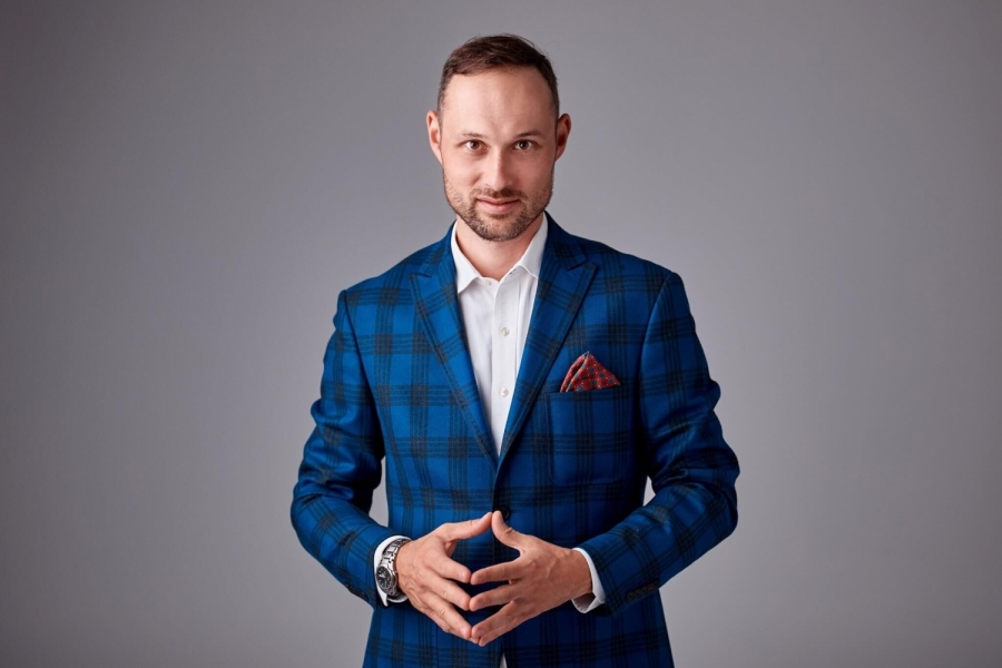 Dr hab. Krzysztof Celuch, prof. UMK - zdjęcie biznesowe mężczyzny, w garniturze w kratkę, mającego złożone ręce. 