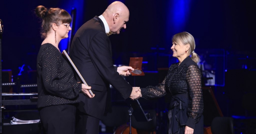 Prof. Alicja Majewska odbiera medal z rąk prezydenta Torunia