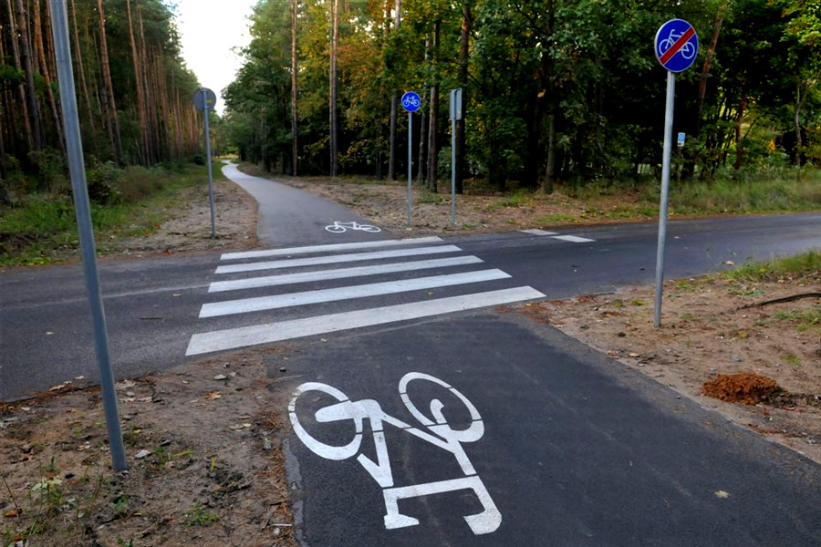 na zdjęciu ścieżka rowerowa z poziomym oznaczeniem - biały rower na asfalcie