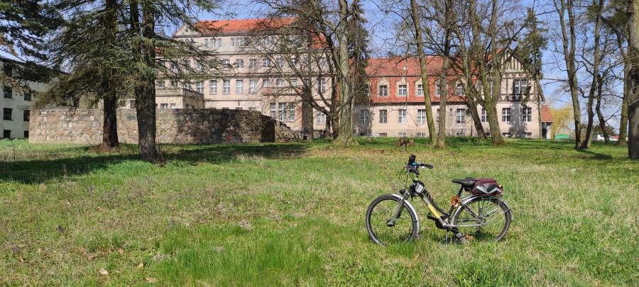 na zdjęciu rower na trawniku, w tle budynek