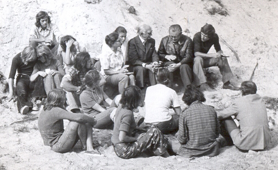 czarno-białe zdjęcie z okresu studiów - w terenie, studenci siędzący wokół profesora