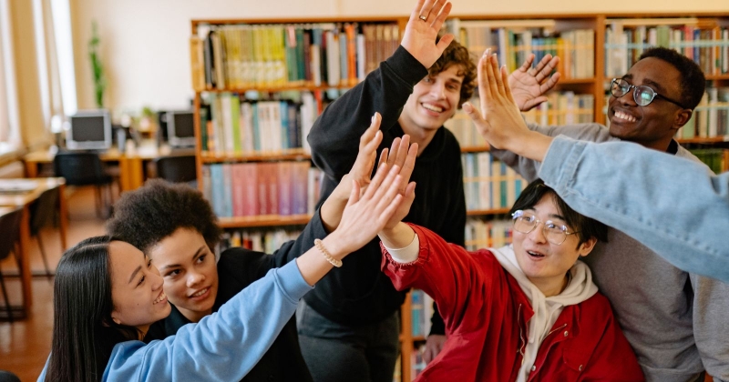 grupa studentów przybijająca "piątkę"