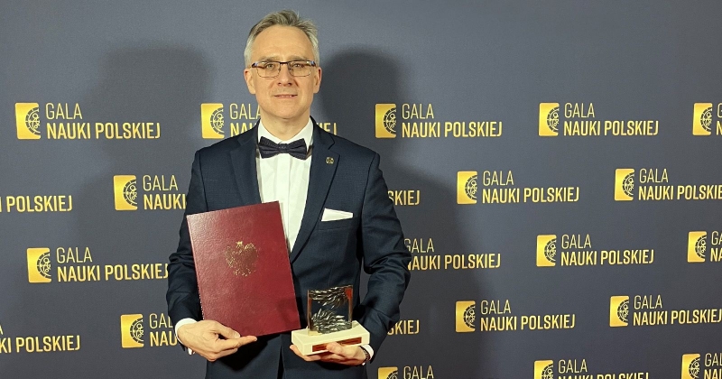 Prof. Zastempowski pozuje na ściance z napisem "Gala Nauki Polskiej" ze statuetką i dyplomem