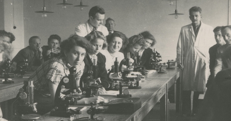 an old, black and white photo of the first students of the NCU in a laboratory