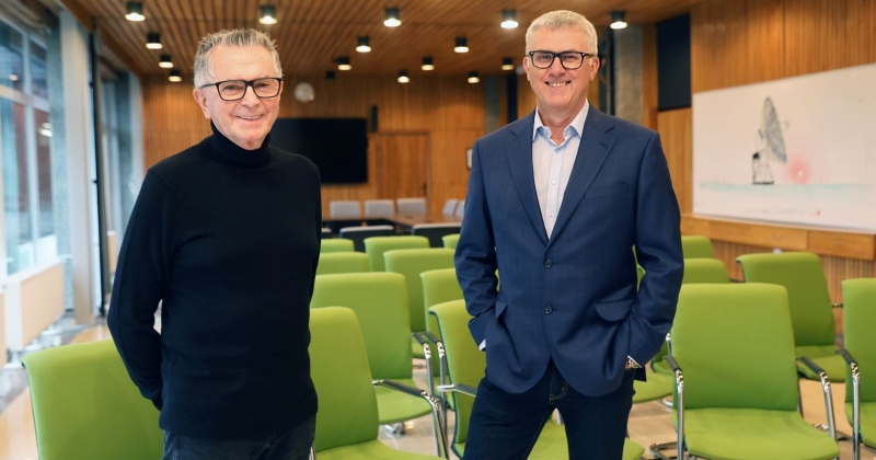 Prof. Aleksander Wolszczan i prof. Andrzej Niedzielski stoją i uśmiechają się, patrząc w obiektyw aparatu