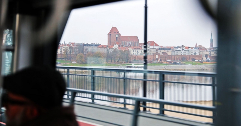 Zdjęcie fragmentu panoramy Torunia zrobione przez okno jadącego przez most autobusu