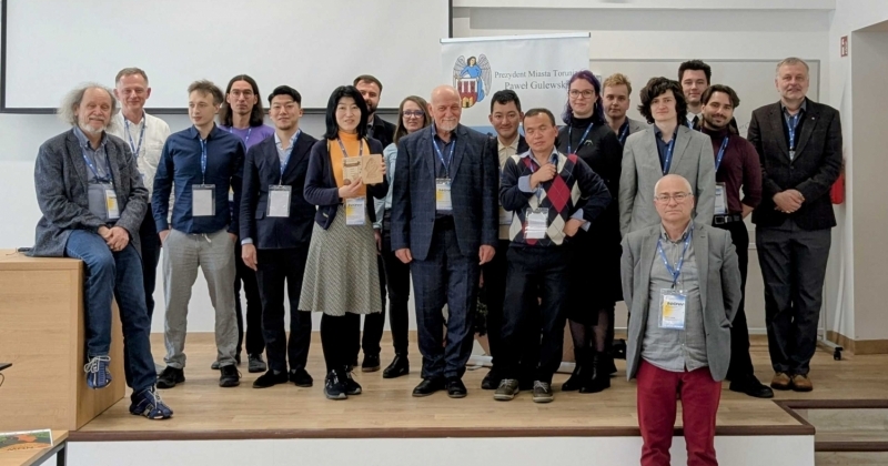 Uczestnicy konferencji pozują do zdjęcia w sali konferencyjnej