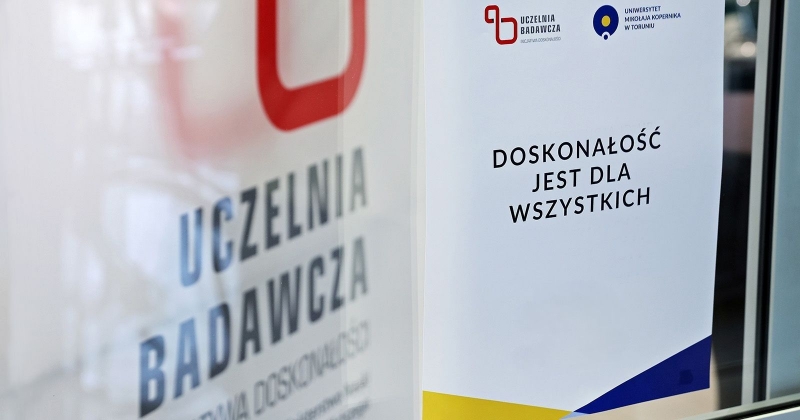 Zdjęcie roll-upu z napisem Uczelnia Badawcza i drugiego z napisem Doskonałość jest dla wszystkich