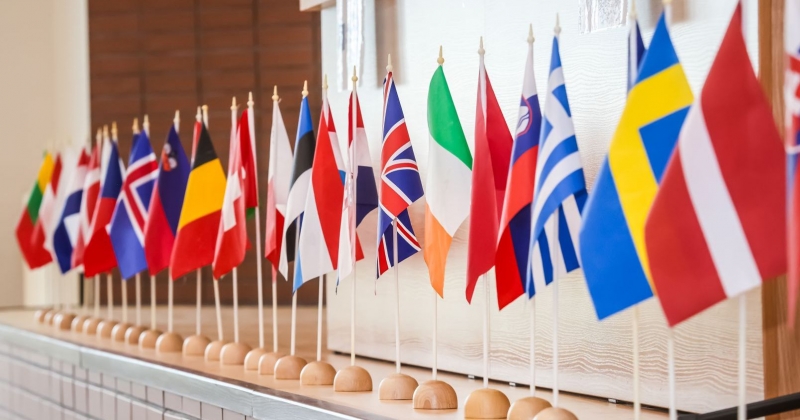 W rządku stoi kilkanaście małych flag róznych państw