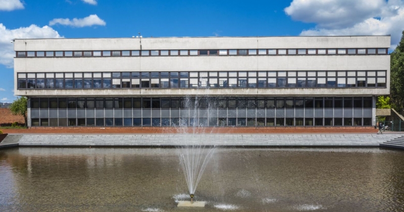 Budynek biblioteki od strony basenu, na środku basenu włączona jest fontanna