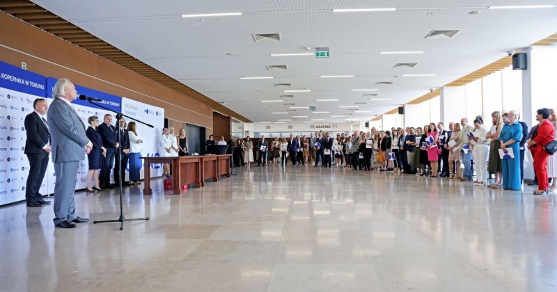 Foyer of the Auditorium, the Rector stands at the microphone, around a large number of employees receiving awards