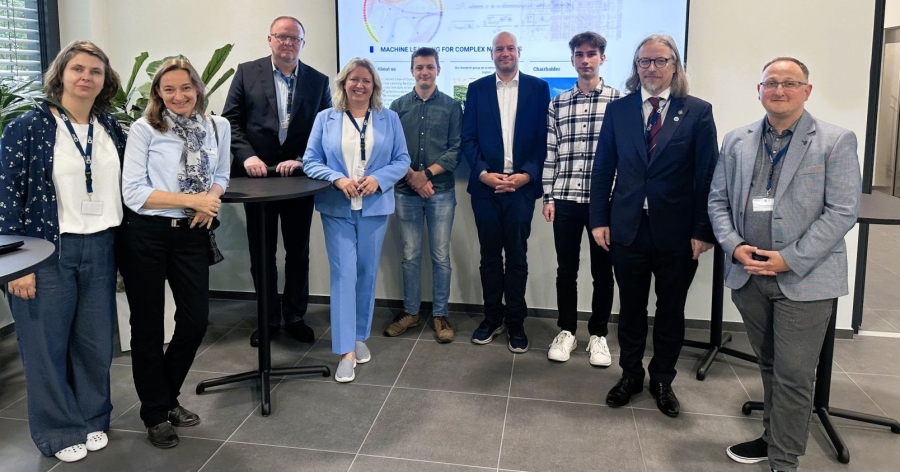 The delegation from UMK and the hosts from Wurzburg (9 people in all) stand side by side, with the presentation in the background